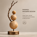 AVOLTT sculpture with three graduated wooden spheres, a curved branch, and a round bark-edged base