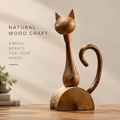 AVOLTT wood cat sculpture with pointed ears, a curled tail, and a semicircular base on a tabletop